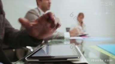 非裔美国人的肖像在数字平板电脑上写字与商务人士在办公室开会期间工作和交谈